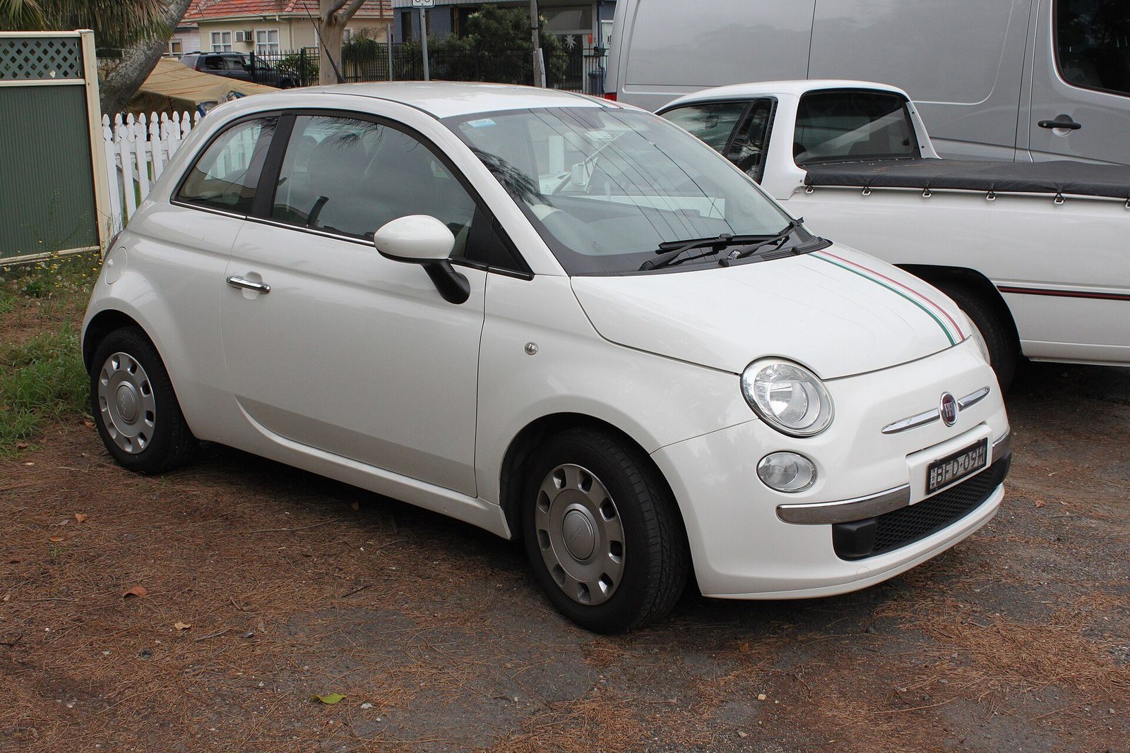 Biały Fiat 500 zaparkowany przy ulicy